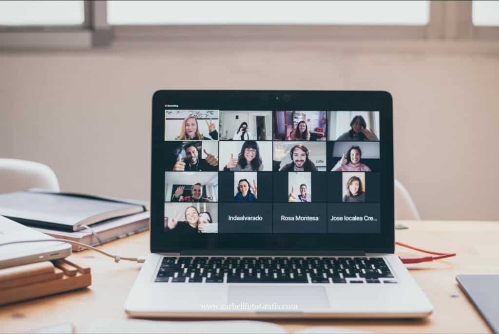 Laptop on desk showing an ongoing virtual meeting with Barbara, the founder of #VirtualSpaceHero, and many others smiling into the camera.